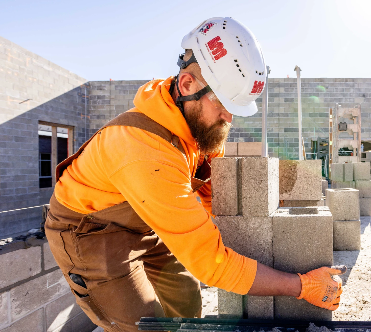 Leonard Masonry team member lifting bricks.